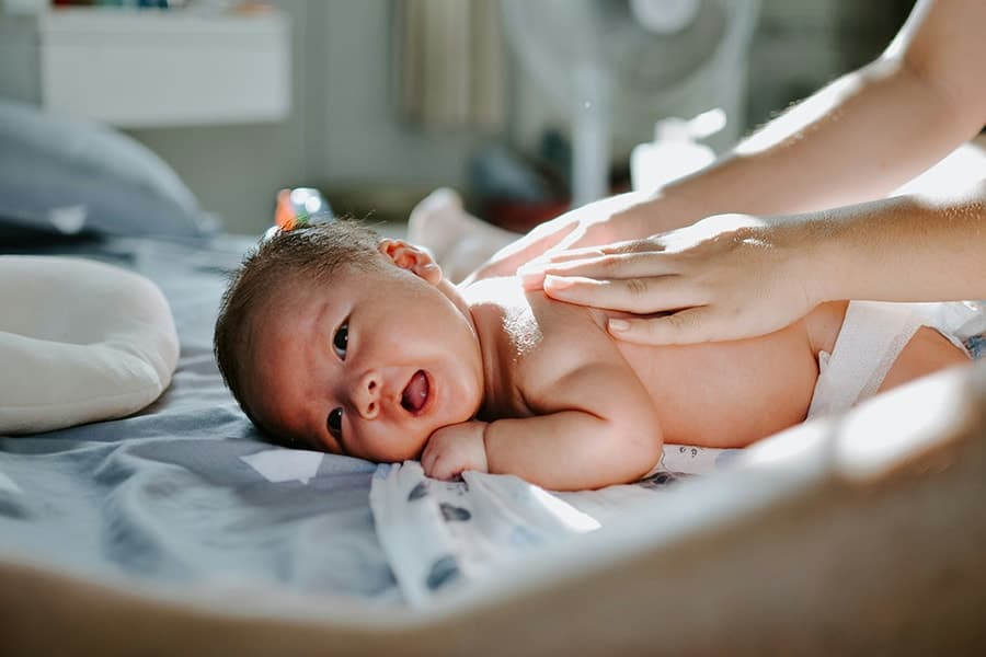 A parent gently massaging their baby's legs — IAIM-accredited baby massage class in Dubai with Lisa Adair